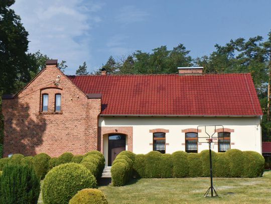 Odnowiona elewacja zabytkowej świetlicy wiejskiej w Mnichusie po remoncie wykonanym przez gminę Ozimek.
