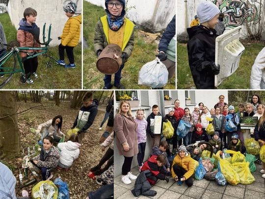 Uczniowie PSP Tarnów Opolski sprzątający teren wokół biblioteki podczas zajęć ekologicznych