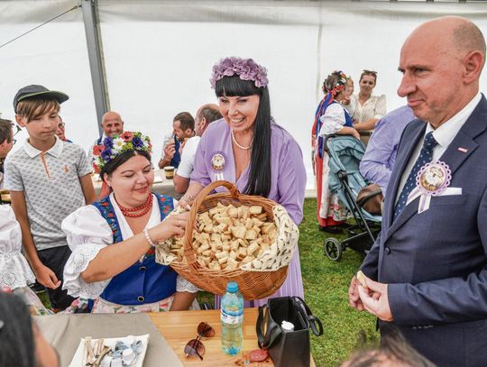 Korowód dożynkowy w Żelaznej z koronami, bryczkami, traktorami i dekoracjami mieszkańców podczas gminno‑parafialnego święta plonów.
