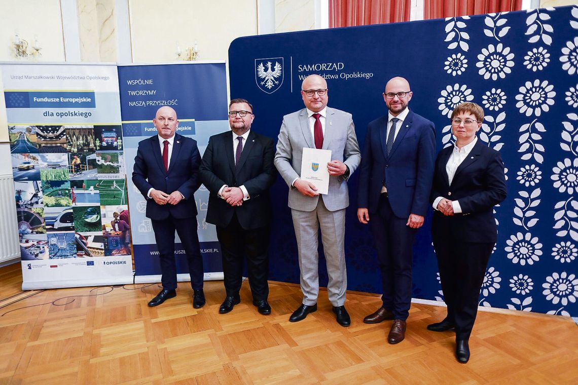 Włodarze gmin odbierają umowy na unijne dofinansowania podczas spotkania w Pałacu w Izbicku