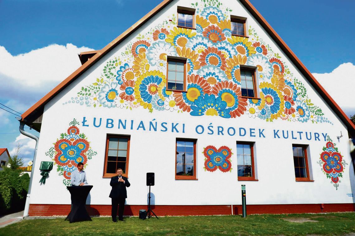 Kwiaty Opolszczyzny na ścianie Łubniańskiego Ośrodka Kultury Kolorowy mural inspirowany opolskim wzorem kwiatowym na ścianie domu kultury w Łubnianach