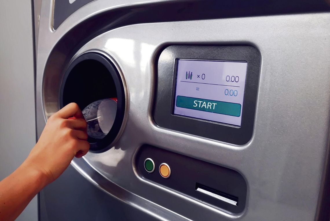 „Automat do zwrotu butelek i puszek w jednym z polskich sklepów — widoczne opakowania w systemie kaucyjnym.”