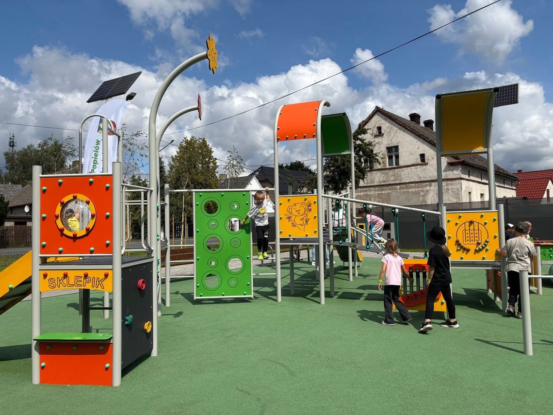 Dzieci bawiące się na nowym, kolorowym placu zabaw w Popielowie podczas oficjalnego otwarcia
