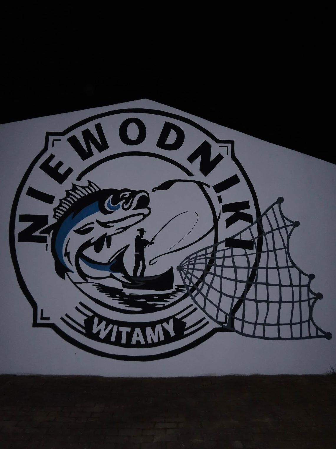 Wędkarz, ryba i sieć – mural, który wita gości