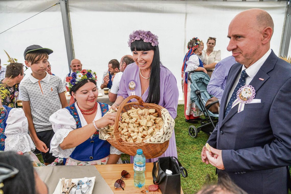 Korowód dożynkowy w Żelaznej z koronami, bryczkami, traktorami i dekoracjami mieszkańców podczas gminno‑parafialnego święta plonów.